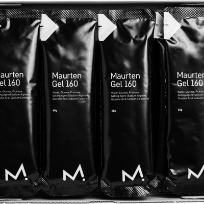 Caixa com quatro saquetas pretas de gel alimentar Maurten Gel 160 com texto branco e logotipo M.