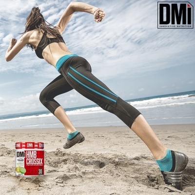 Mulher a correr na praia com leggings pretas e riscas azuis e embalagem suplemento DMI