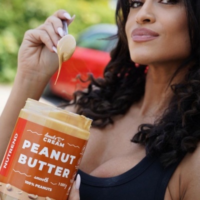 Frasco de manteiga de amendoim com mulher segurando colher e frasco em ambiente exterior