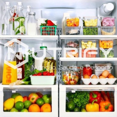 Frigorífico organizado com alimentos frescos, frutas, legumes e ovos em recipientes e caixas.