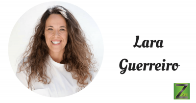 Mulher sorridente com t-shirt branca e texto 'Lara Guerreiro' em fundo branco