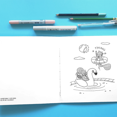 Caderno aberto com desenho a preto e branco e vários instrumentos de escrita sobre superfície azul