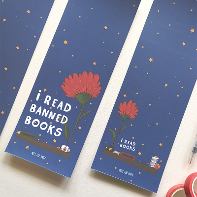 Três marcadores de livro azuis com estrelas douradas, flor vermelha e estante desenhada com livros e objetos