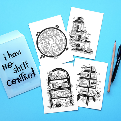 Cartões-postais com ilustrações a preto e branco, envelope azul claro com texto e duas canetas sobre fundo azul