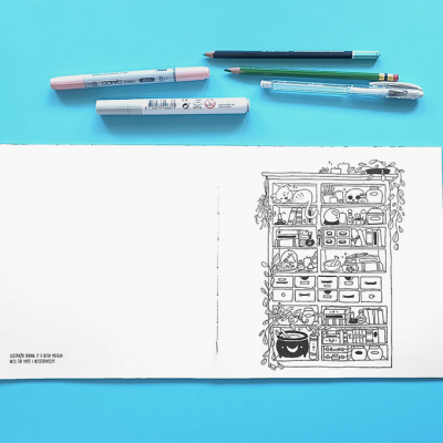 Folheto aberto com desenho a preto e branco de estante cheio de objectos, lápis e marcador sobre fundo azul