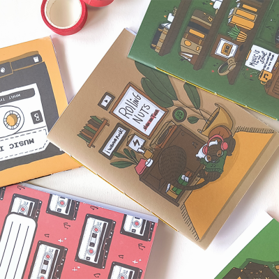 cadernos ilustrados com capas coloridas e fita adesiva
