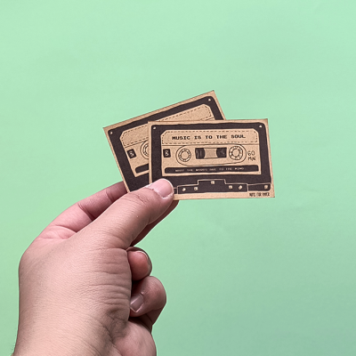 Dois cartões castanhos em forma de cassete com texto 