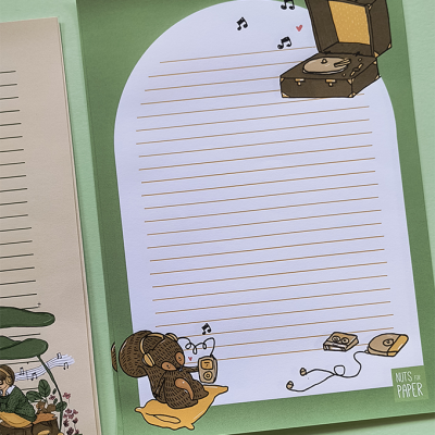 Folha de papel para escrita com ilustrações de um urso a ouvir música e uma fornalha de vinil