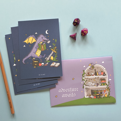 Cadernos ilustrados, lápis e dados coloridos sobre fundo azul claro