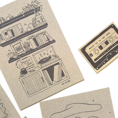 Cartões postais com desenhos e textos sobre música, e caneta dourada