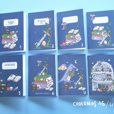 Oito cadernos A6 com capas azuis e desenhos coloridos variados