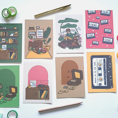 Cartões ilustrados retro com material de escrita sobre mesa branca