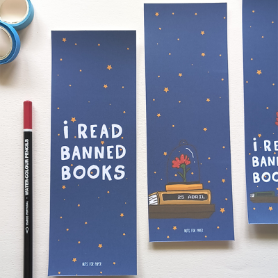 Marcadores de página azuis com texto e estrelas cor de laranja, lápis aquarela vermelho à esquerda