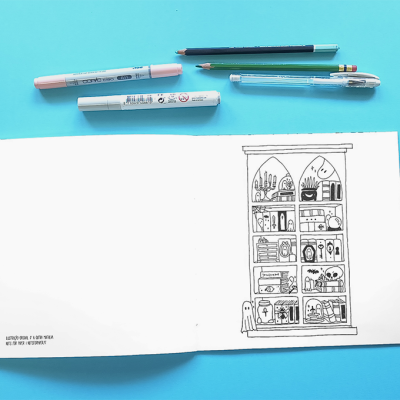 Folha branca com desenho preto de estante detalhada e canetas coloridas sobre fundo azul