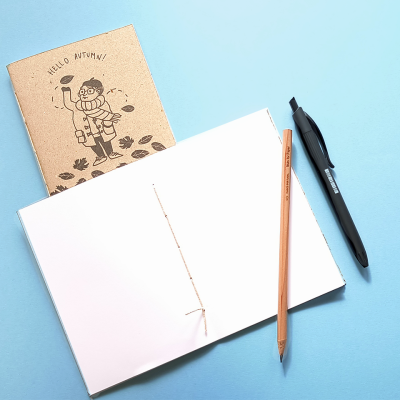 cadernos, lápis e caneta sobre fundo azul