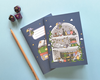 Dois cadernos ilustrados com livros e animais, lápis de madeira e dados coloridos sobre fundo azul