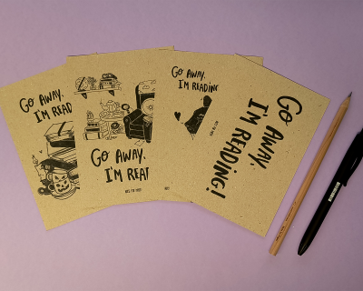 Postais de papel reciclado com texto e ilustrações, lápis e caneta sobre fundo lilás.