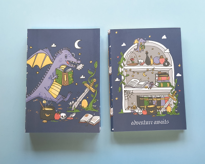 Dois cadernos ilustrados com dragão e estante mágica em fundo azul escuro