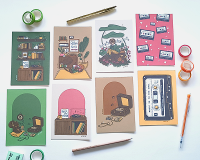 Cartões ilustrados retro com material de escrita sobre mesa branca