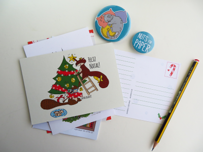 Postais de Natal com ilustrações e bottons coloridos sobre mesa branca