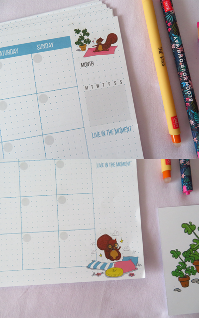 Página de calendário mensal com ilustrações de esquilos, texto em azul e canetas coloridas num fundo rosa claro