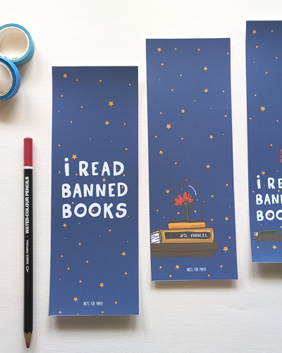 Marcadores de página azuis com texto e estrelas cor de laranja, lápis aquarela vermelho à esquerda