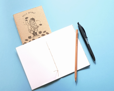 cadernos, lápis e caneta sobre fundo azul