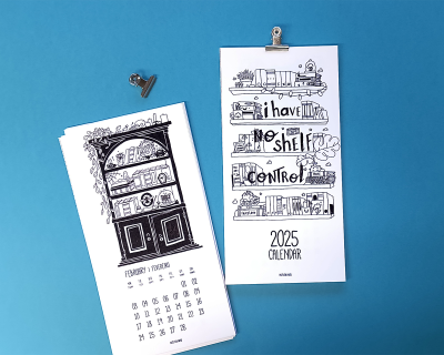 Dois calendários de parede com ilustrações a preto em papel branco, pendurados por prendedores metálicos sobre fundo azul claro.