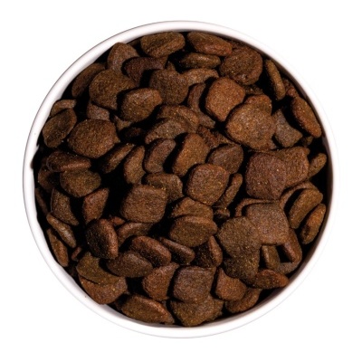 Recipiente branco cheio de ração castanha escura para animais.