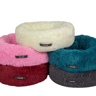 Quatro camas redondas para animais em cores creme, rosa, azul e vermelho escuro com etiqueta 'Primoid'.