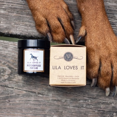 Frascos LILA LOVES IT Pawcare junto às patas de cão sobre madeira rústica
