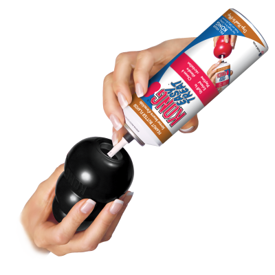 Pessoa a despejar comida NUNS TREAT para cães numa embalagem preta arredondada