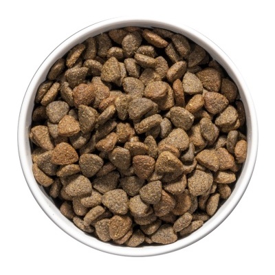 Tigela branca com croquetes secos triangulares castanhos.