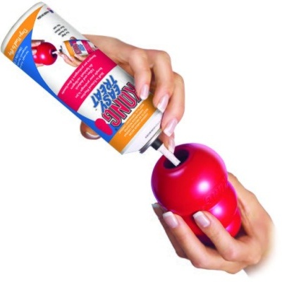 Aplicação de spray num brinquedo canino vermelho em esferas