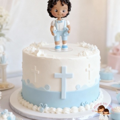 Bolo decorado para celebração com figura de menino em cima e cruzes azuis e brancas.