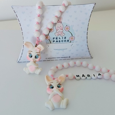 Colar infantil com contas brancas e coelhinho, embalagem com texto Feliz Páscoa.