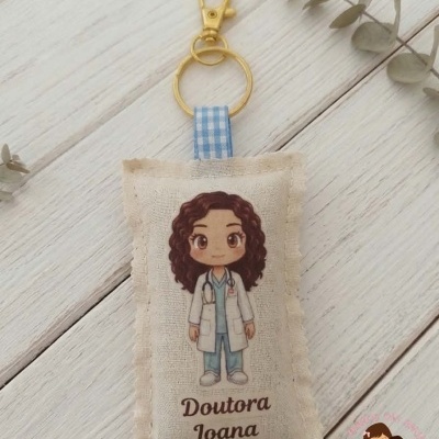 Porta-chaves almofadado com imagem de doutora e texto Doutora Joana sobre superfície de madeira clara