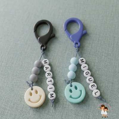 Dois porta-chaves coloridos com nomes e pendentes sorridentes