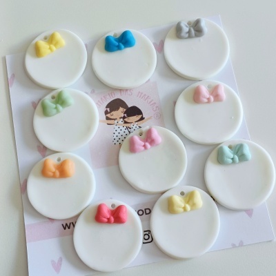 Medalhas redondas brancas com laços coloridos num cartão decorativo