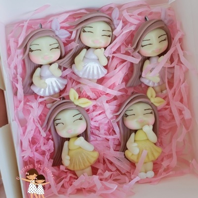 Cinco bonecas decorativas em papel de seda rosa numa caixa branca