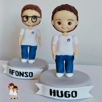 Bonecos personalizados de menino sobre bases com nomes Afonso e Hugo.