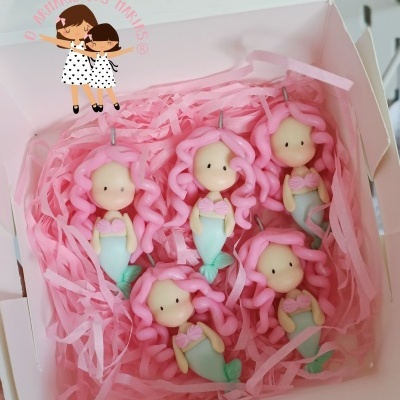 Cinco velas em forma de sereia com cabelos rosa em caixa branca