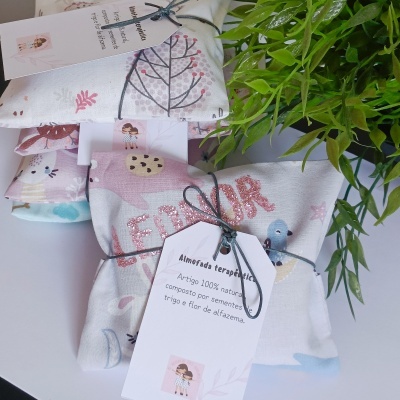 Almofadas terapêuticas coloridas com desenhos de natureza e animais, embaladas com etiqueta em português.