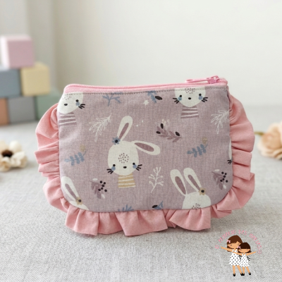 Bolsa de tecido rosa com padrão de coelhos brancos com detalhes flores e folhas.