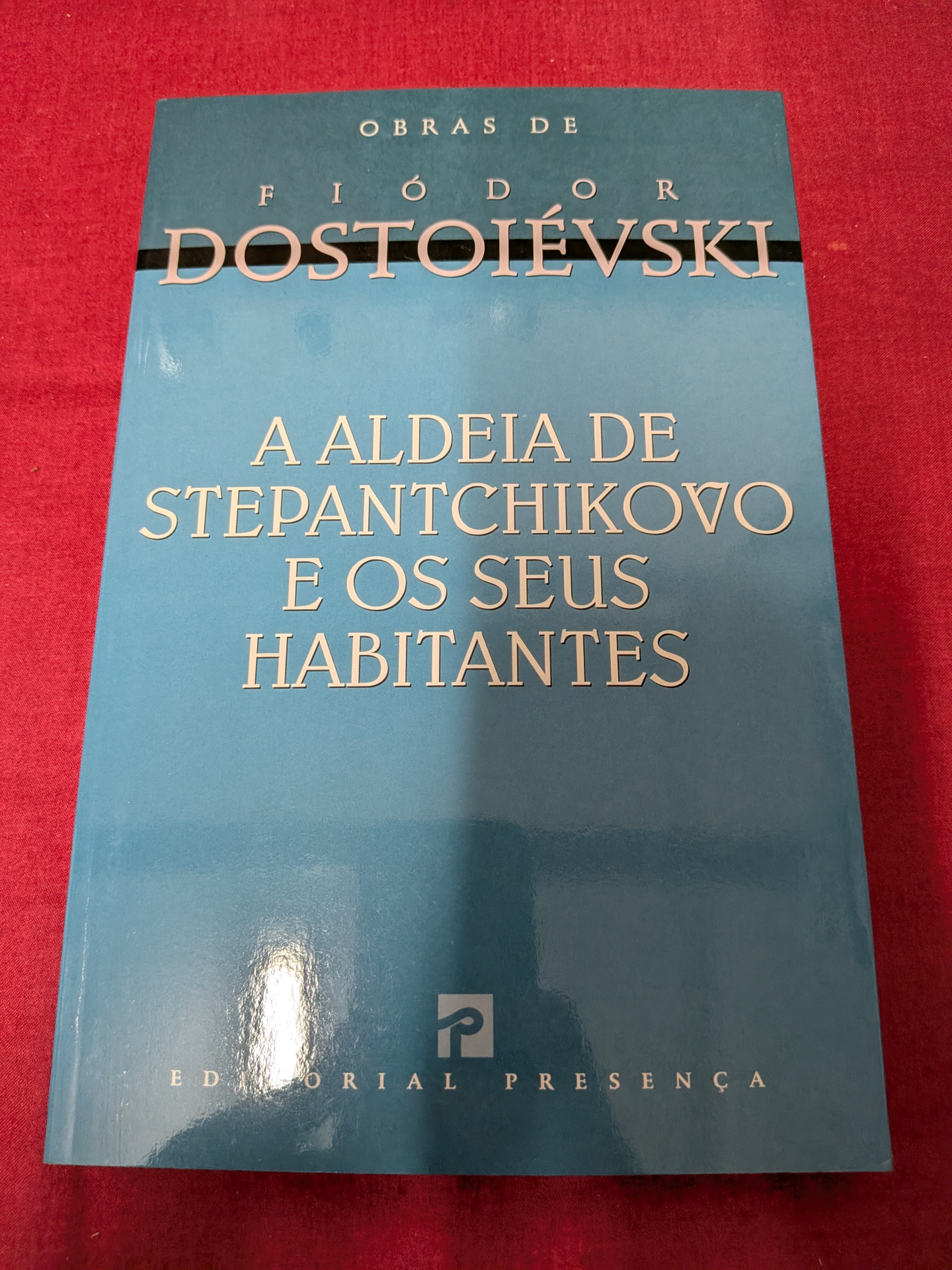 A Aldeia de Stepantchikovo e os Seus Habitantes de Fiódor Dostoiévski Livro azul de Fiódor Dostoiévski sobre fundo vermelho