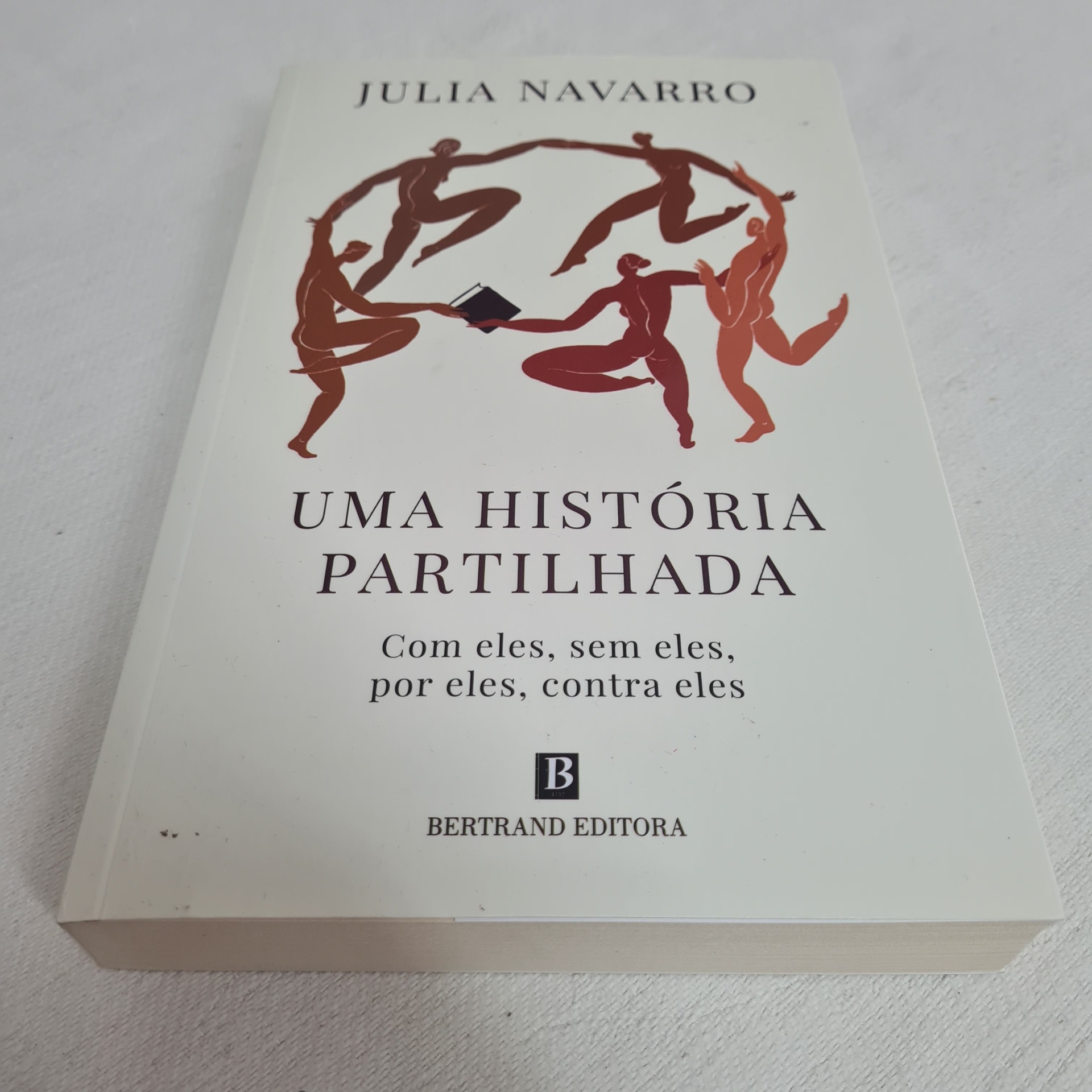Julia Navarro - Uma História Partilhada Capa de livro branca com título, autor e ilustração de figuras humanas a dançar em círculo