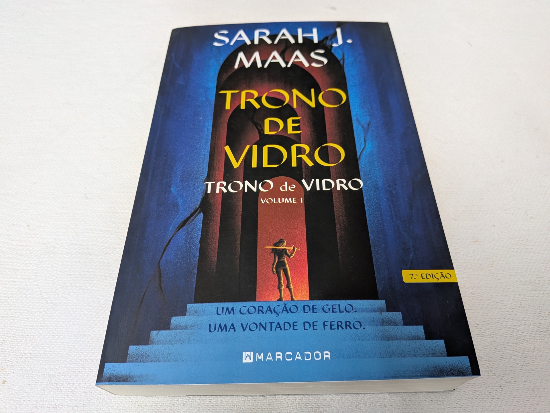 Sarah J. Maas - Trono de Vidro (Trono de Vidro - Livro 1) (defeito na capa) Capa do livro 'Trono de Vidro' de Sarah J. Maas com escadaria azul e figura humana