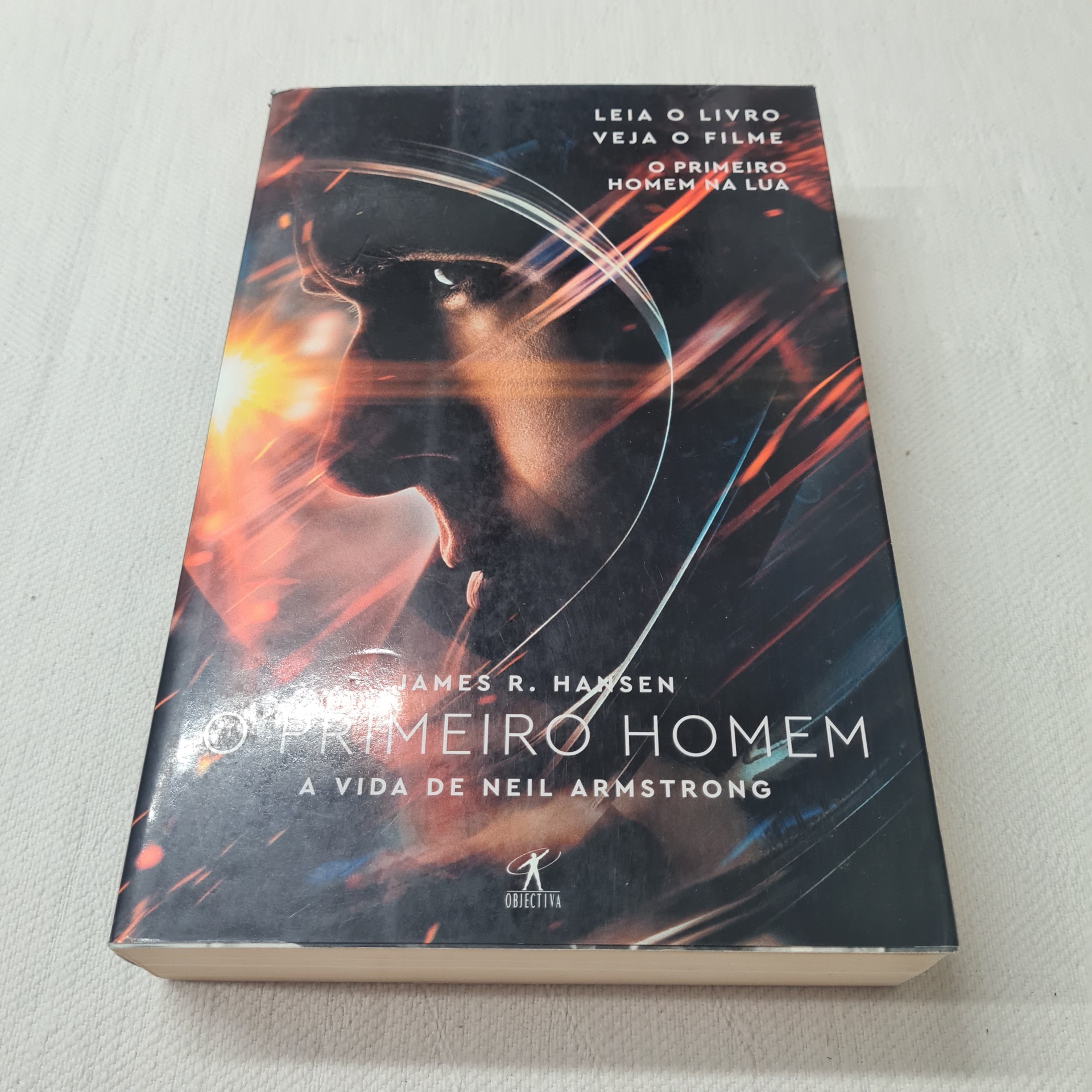 James R. Hansen - O Primeiro Homem Capa de livro com rosto de astronauta e texto relacionado a Neil Armstrong.