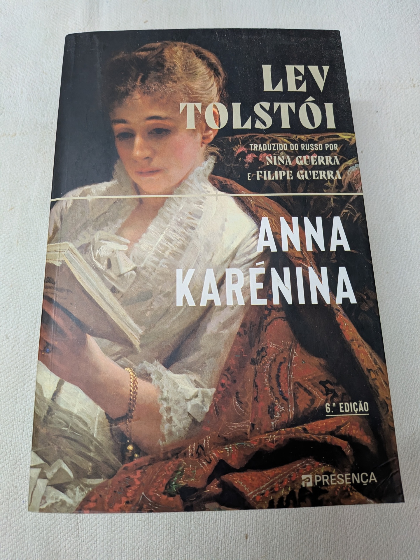 Lev Tolstói - Anna Karénina (defeito na capa) Capa do livro Anna Karénina de Lev Tolstói com pintura de mulher vestindo roupa branca a ler um livro