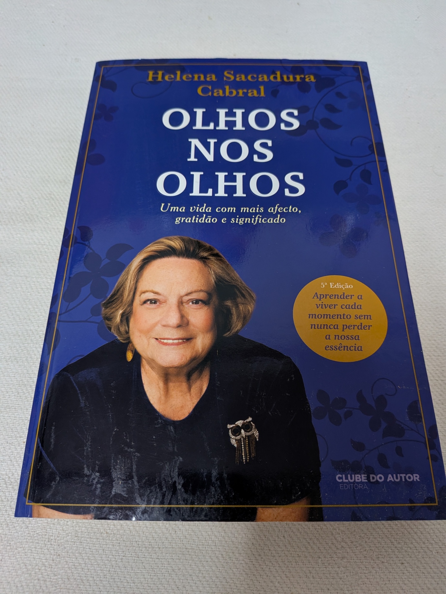 Helena Sacadura Cabral - Olhos nos Olhos Livro Olhos nos Olhos de Helena Sacadura Cabral com capa azul e foto da autora